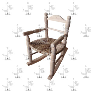Sillón mecedor infantil torneado con asiento forrado en junco con apoya brazos, respaldo de dos fajas horizontales y patas reforzadas con dos parantes hecho de madera de pino. Fabricado por JS. Fábrica de muebles.
